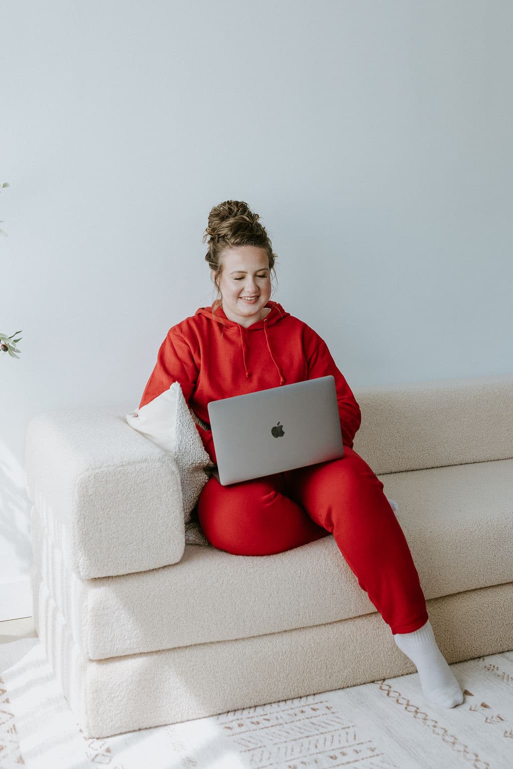 Megan Nakazawa working on her laptop on the couch