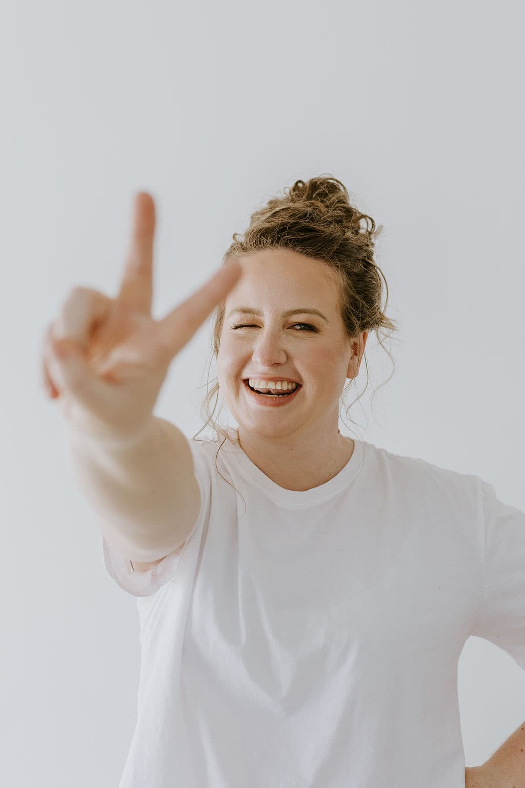 Megan Nakazawa smiling and holding up a peace sign
